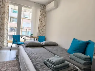 a bedroom with a large bed with blue pillows at Apartment Oborishte in Burgas City