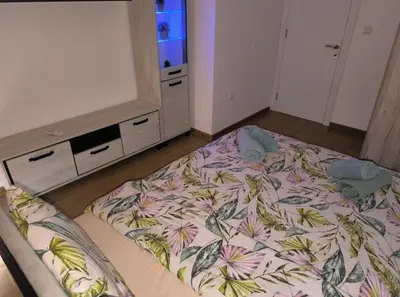 a bedroom with a bed with a floral bedspread at Apartment Oborishte in Burgas City
