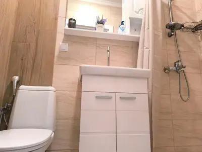 a bathroom with a toilet and a sink and a shower at Apartment Oborishte in Burgas City