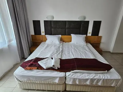 a bedroom with a large bed with a wooden headboard at Mirage Family Hotel in Primorsko