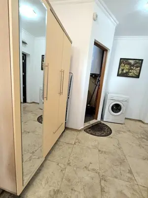 a bathroom with a door and a washing machine at Apartment Rilska - Center and Sea Garden in Burgas City