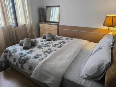 a bedroom with a bed with two pillows and a television at Apartment Rilska - Center and Sea Garden in Burgas City