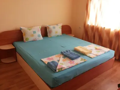 a bedroom with a bed with blue sheets and pillows at Ivanovi Guest House in Primorsko