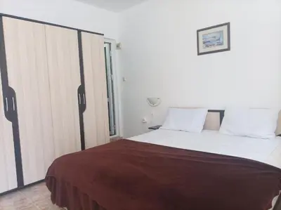 a bedroom with a large bed and a window at Family Hotel Magnolia - Summer residence in Primorsko