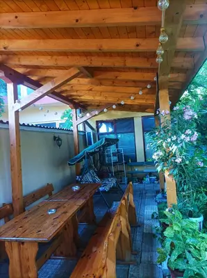 a patio with a wooden table and benches at Family Hotel Magnolia - Summer residence in Primorsko