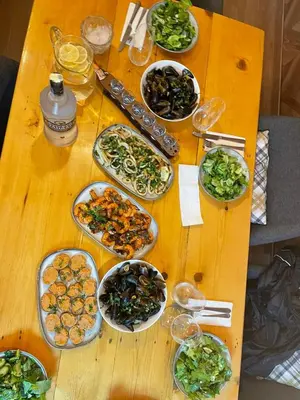 a wooden table with plates of food on it at Family Hotel Magnolia - Summer residence in Primorsko