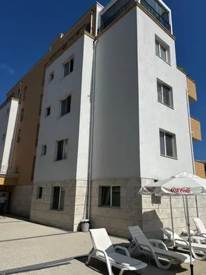 a group of chairs and an umbrella in front of a building at Obzor in Obzor
