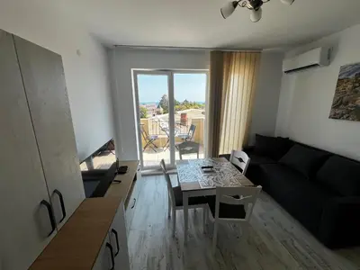 a living room with a black couch and a table at Obzor in Obzor