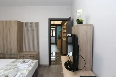 a bedroom with a bed and a tv in a room at Апартамент за гости Мечта Лазур in Burgas City