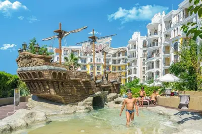 a man in the water in front of a pirate ship fountain at 1 bedroom Harmony Monte Carlo in Sunny Beach