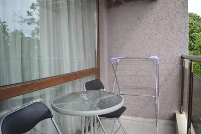 a table and chairs on a balcony with a window at Hotel Lazur in Kiten