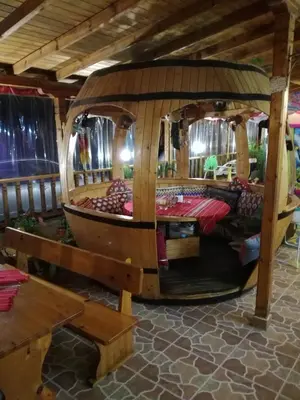 a large wooden boat in a room with a table at Hotel Lazur in Kiten