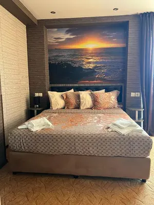a bedroom with a large painting above a bed at Hotel Lazur in Kiten