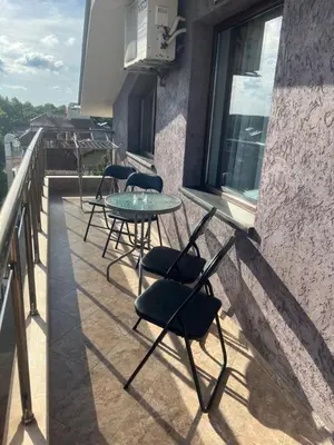 a balcony with chairs and a table on a building at Hotel Lazur in Kiten