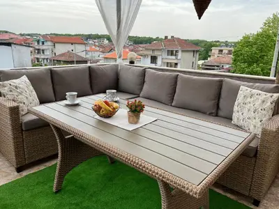 a coffee table on a patio with a couch at Hotel Lazur in Kiten