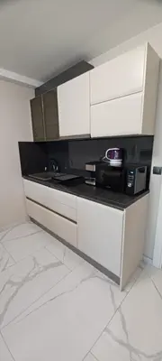 a kitchen with white cabinets and a microwave at Magic Home in Obzor