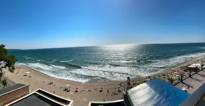 a beach with a crowd of people and the ocean at Magic Home in Obzor
