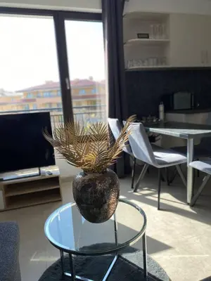 a vase on a glass table in a living room at Apartment mit Meeresblick Polarstar Beach 2 Zimmer Premium Apartment in Sveti Vlas