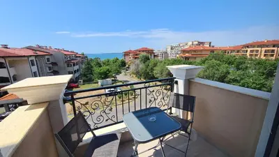 a balcony with a suitcase sitting on a chair on a balcony at Apartment mit Meeresblick Polarstar Beach 2 Zimmer Premium Apartment in Sveti Vlas