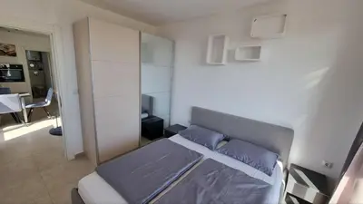a bedroom with a bed with blue pillows at Apartment mit Meeresblick Polarstar Beach 2 Zimmer Premium Apartment in Sveti Vlas