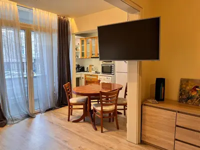 a kitchen and dining room with a table and a television at Cozy Central Apartment Steps from Everything! in Varna City