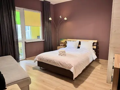a bedroom with a large bed and a window at Cozy Central Apartment Steps from Everything! in Varna City