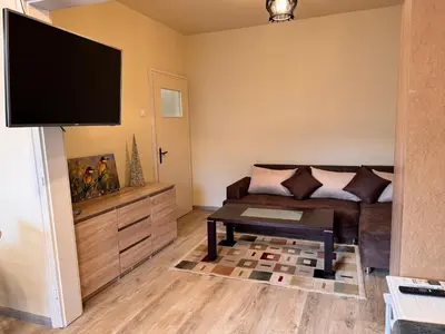 a living room with a couch and a flat screen tv at Cozy Central Apartment Steps from Everything! in Varna City