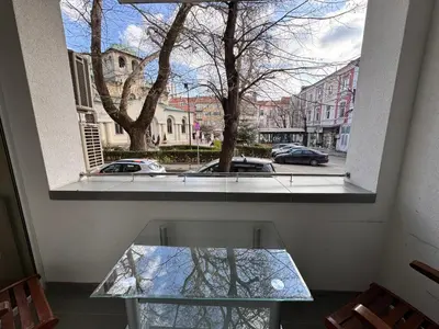 a window with a glass table in front of a street at Cozy Central Apartment Steps from Everything! in Varna City