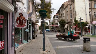 a group of people sitting on a bench on a street at Luxury Apartments Central KIRIL I METODII 3 in Burgas City