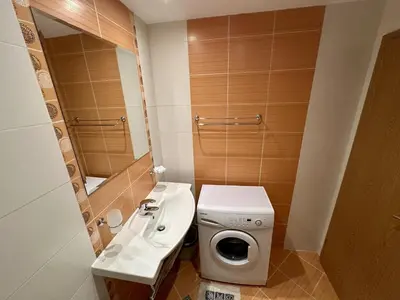 a small bathroom with a sink and a washing machine at River Park Menada Apartments in Sunny Beach
