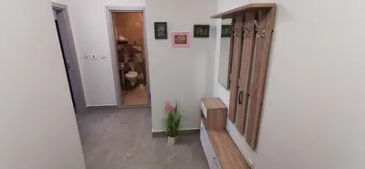a hallway with a wooden bench in a room at Ах, морето 2 in Burgas City