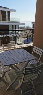 a table and a chair sitting on a balcony at Ах, морето 2 in Burgas City