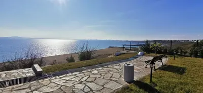 a bench sitting next to a walkway next to the water at Ах, морето 2 in Burgas City