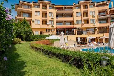 a hotel with a swimming pool in front of a building at Paradise Dreams Menada Apartments in Sveti Vlas