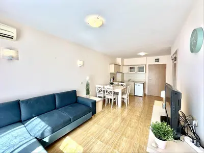a living room with a blue couch and a kitchen at Paradise Dreams Menada Apartments in Sveti Vlas