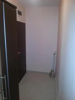 a hallway with a black door and a tile floor at Apartment Nova in Burgas City