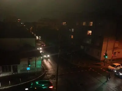 a city street at night with a green traffic light at Apartment Nova in Burgas City