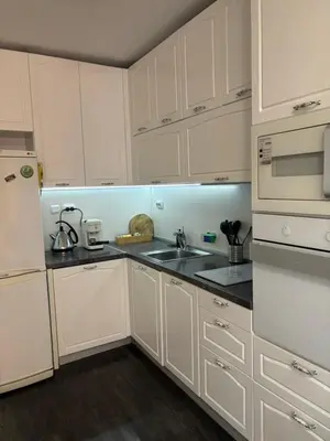 a white kitchen with white cabinets and a sink at Apartment 4 Plus Burgas in Burgas City
