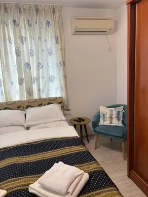 a bedroom with a bed and a chair and a window at Apartment 4 Plus Burgas in Burgas City