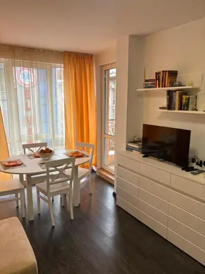 a living room with a table and a television at Apartment 4 Plus Burgas in Burgas City