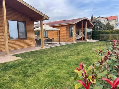 a log home with a yard and a house at Вили Панорама 2 in Chernomorets