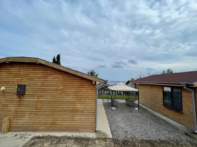 a wooden building with a patio next to a house at Вили Панорама 2 in Chernomorets