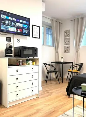 a living room with a white dresser with a tv on the wall at Studio Sea Garden in Varna City