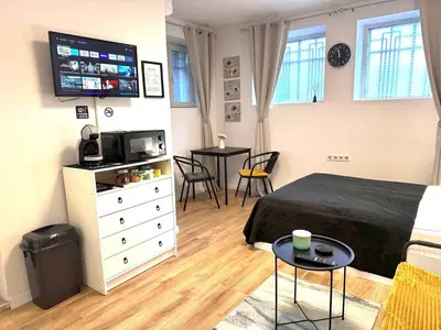 a bedroom with a bed and a tv and a table at Studio Sea Garden in Varna City