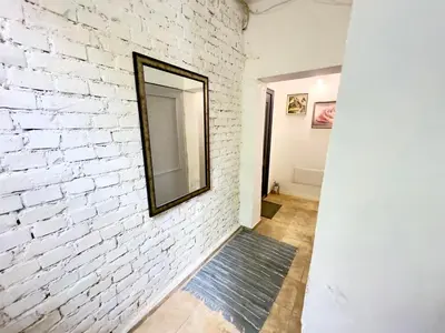 a brick wall with a mirror and a rug at Studio Sea Garden in Varna City