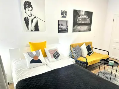 a bedroom with a bed and a yellow chair at Studio Sea Garden in Varna City