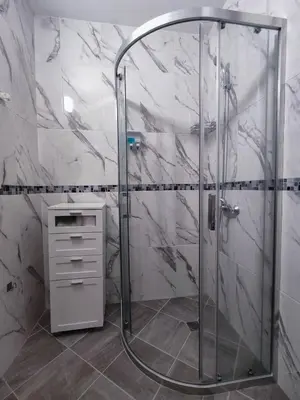 a shower with a glass door in a bathroom at Nelly's Place 10 in Shkorpilovtsi