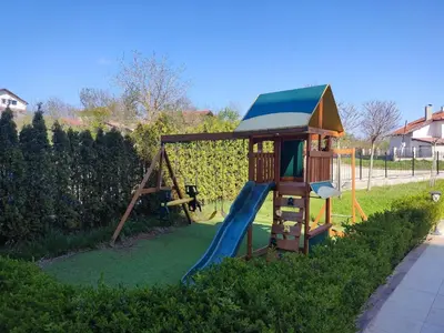a playground with a slide and a play house at Nelly's Place 10 in Shkorpilovtsi