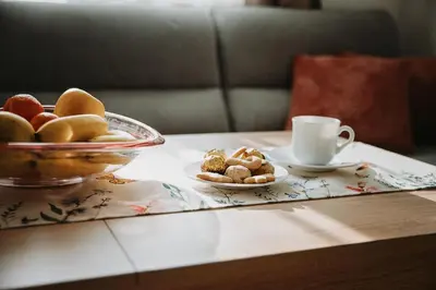 a table with a bowl of fruit and a cup of coffee at Smile City Apartment in Varna City