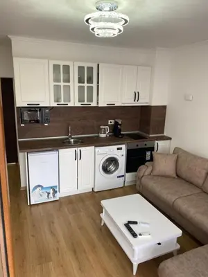 a small living room with a couch and a kitchen at Апартамент Дани in Obzor